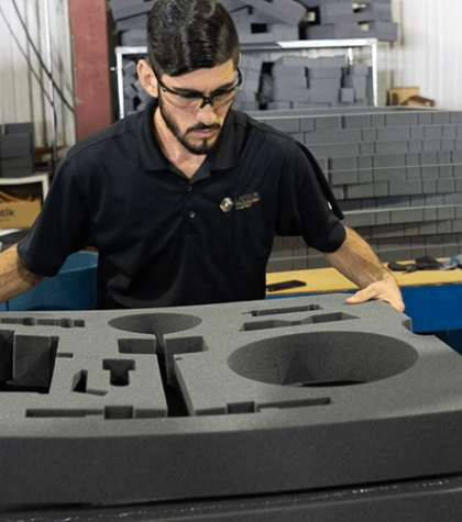LPC team member is inspecting a custom fabricated foam set insert for custom packaging