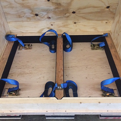 Equipment tie down solution for a custom industrial crate by Larson Packaging Company